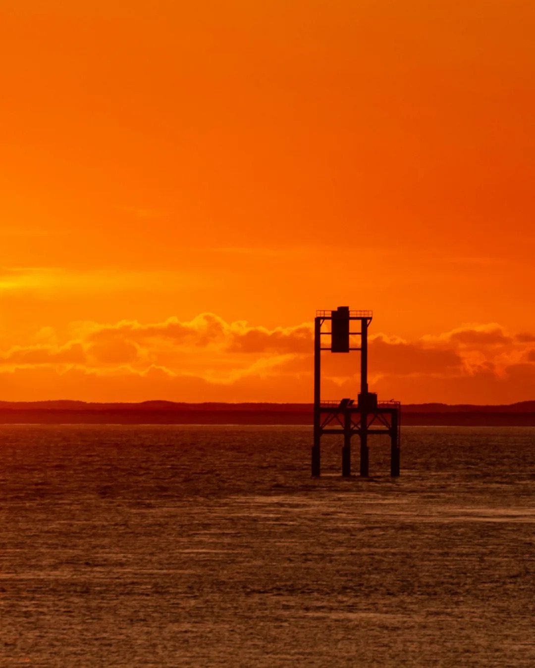 Balise en mer au coucher du soleil, à Royan